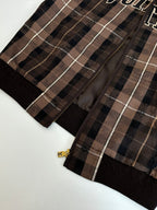 Plaid jacket front with black zipper and gold logo pull tab
