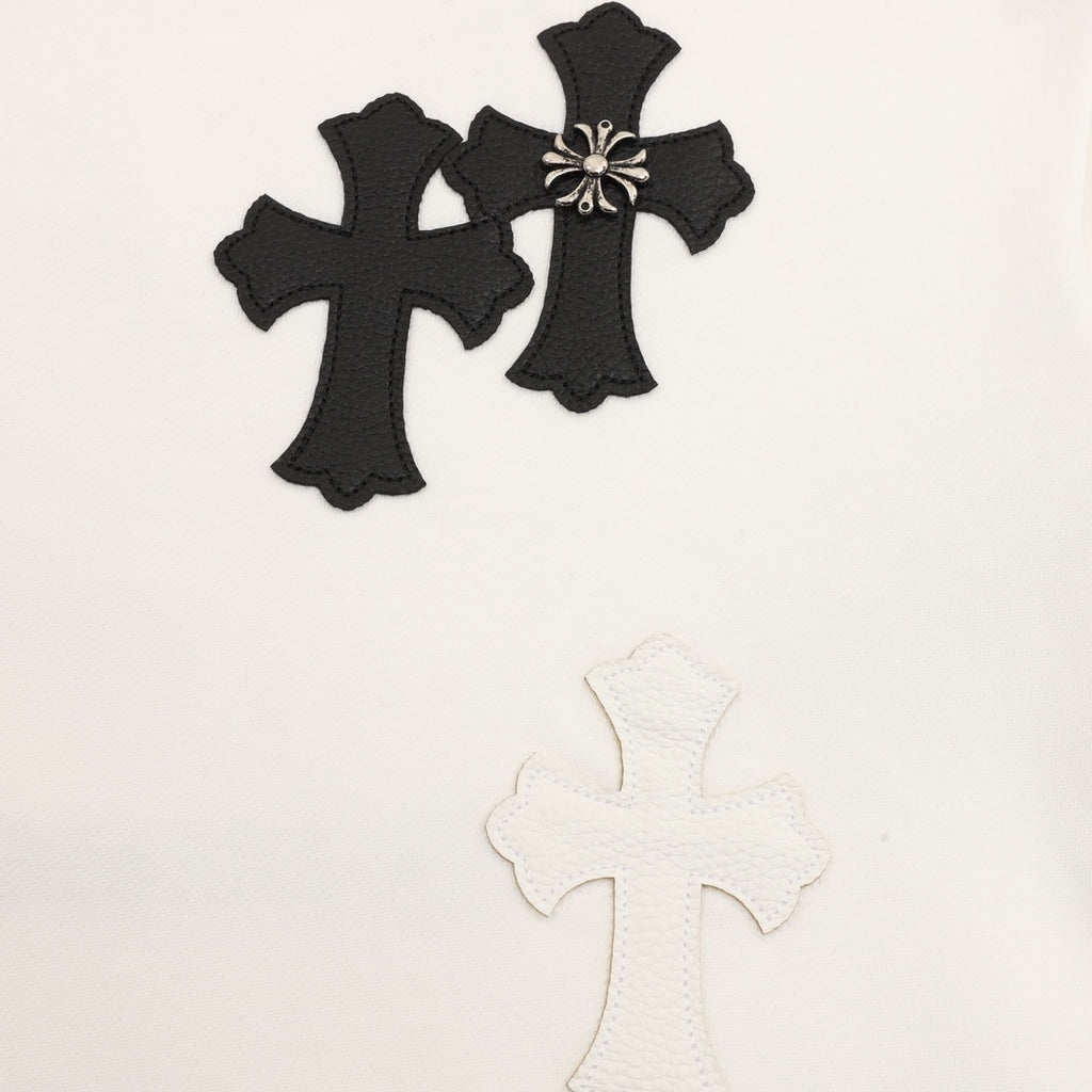 White sweatshirt with black embroidered cross appliques and a small bow detail