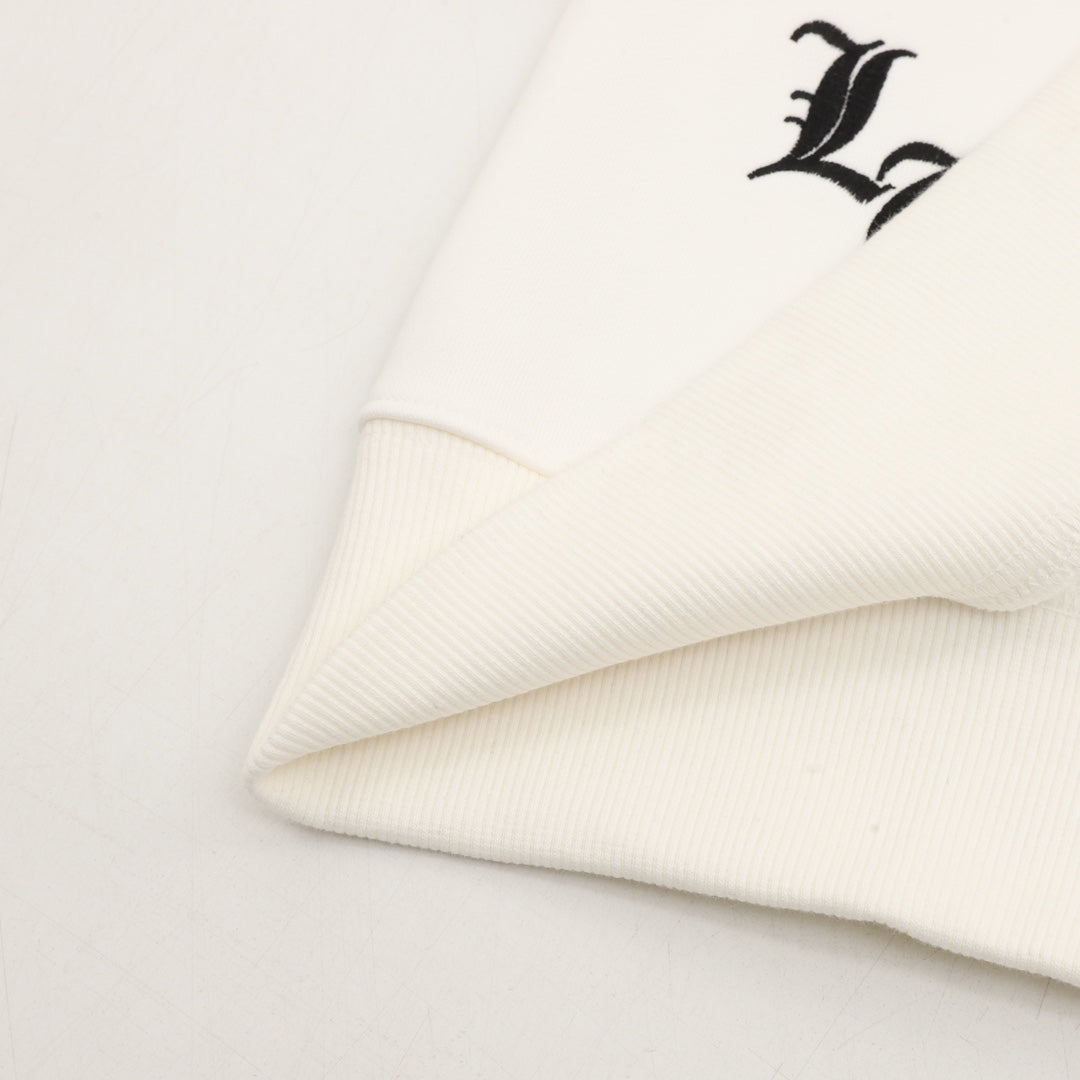 White sweatshirt sleeve with embroidered black letter graphic