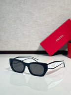 Sunglasses with black frames and dark lenses, Prada logo on temple.