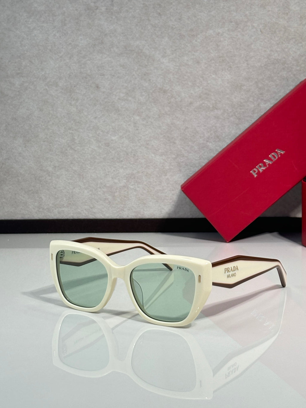 Prada glasses with white frames and green tinted lenses