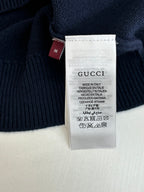 Clothing size and care tag on navy knit sweater with Gucci branding