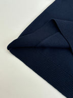 Navy knit sweater close-up of collar seam and ribbed sleeve cuff