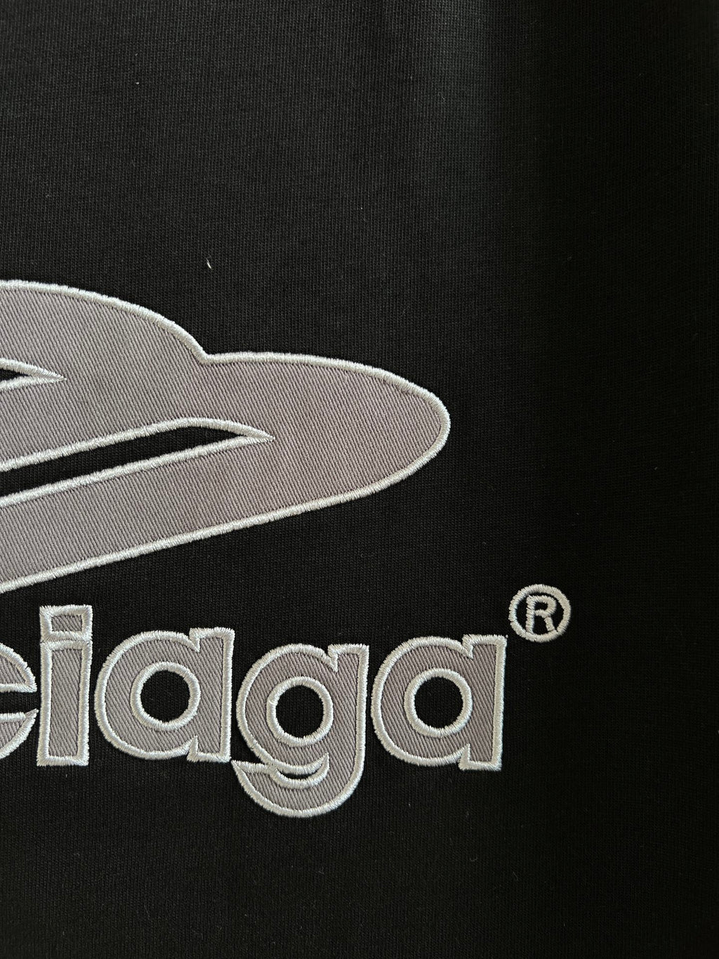 Close-up of black T-shirt chest graphic with embroidered Balenciaga lettering