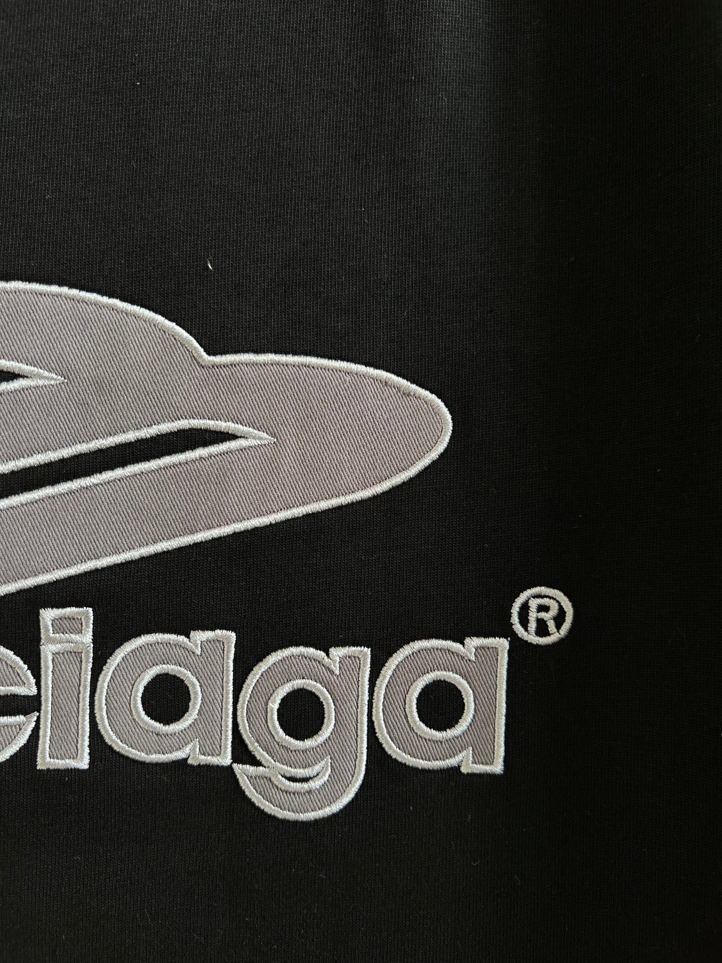 Close-up of black T-shirt chest graphic with embroidered Balenciaga lettering