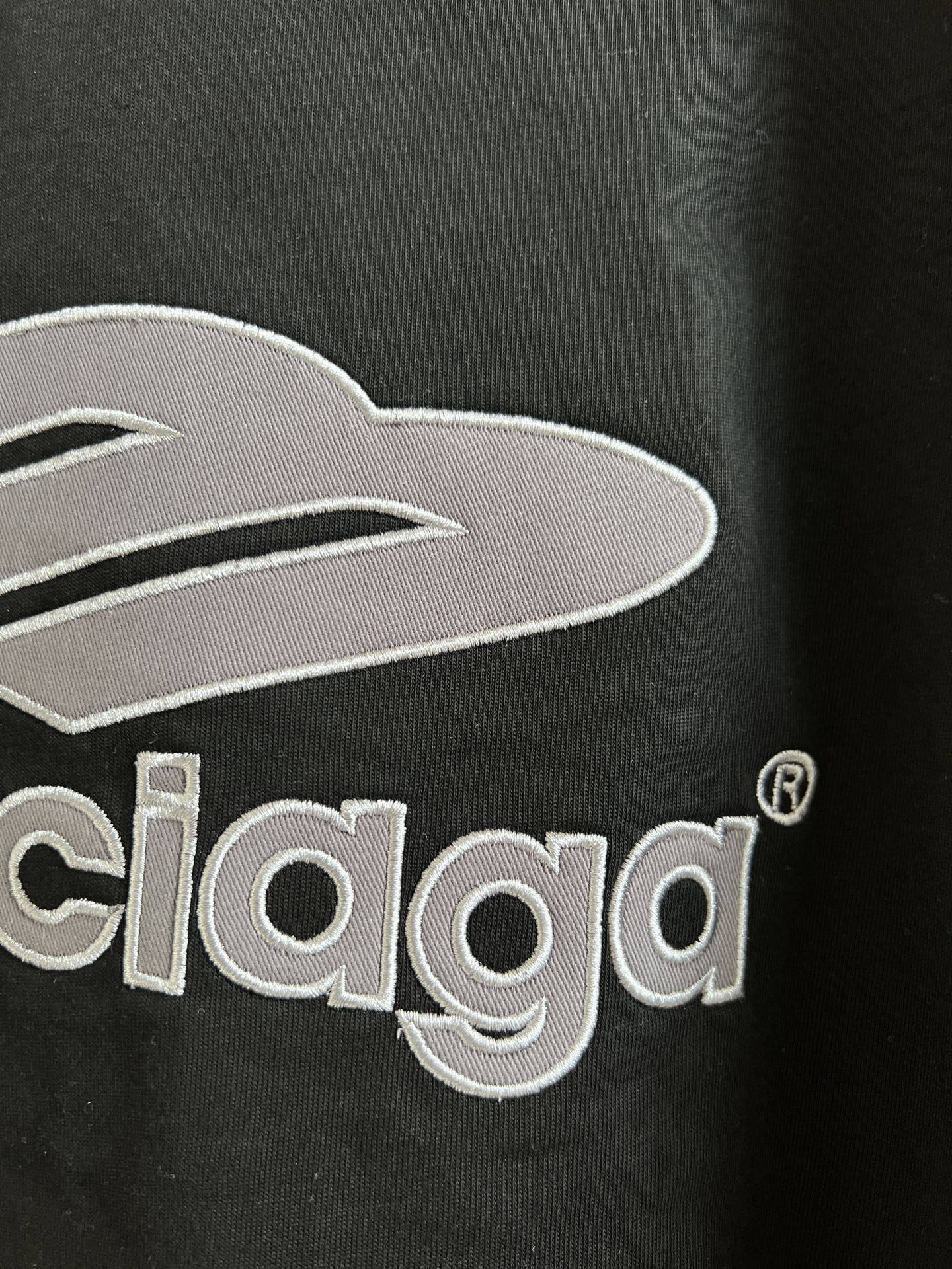 Close-up of black T-shirt chest logo with Balenciaga lettering embroidery