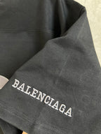 Black T-shirt sleeve with Balenciaga text embroidery along cuff