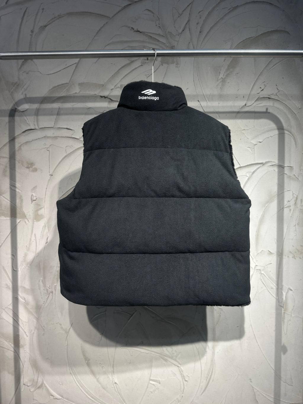 Long black puffer jacket with hood, front zipper and wide collar
