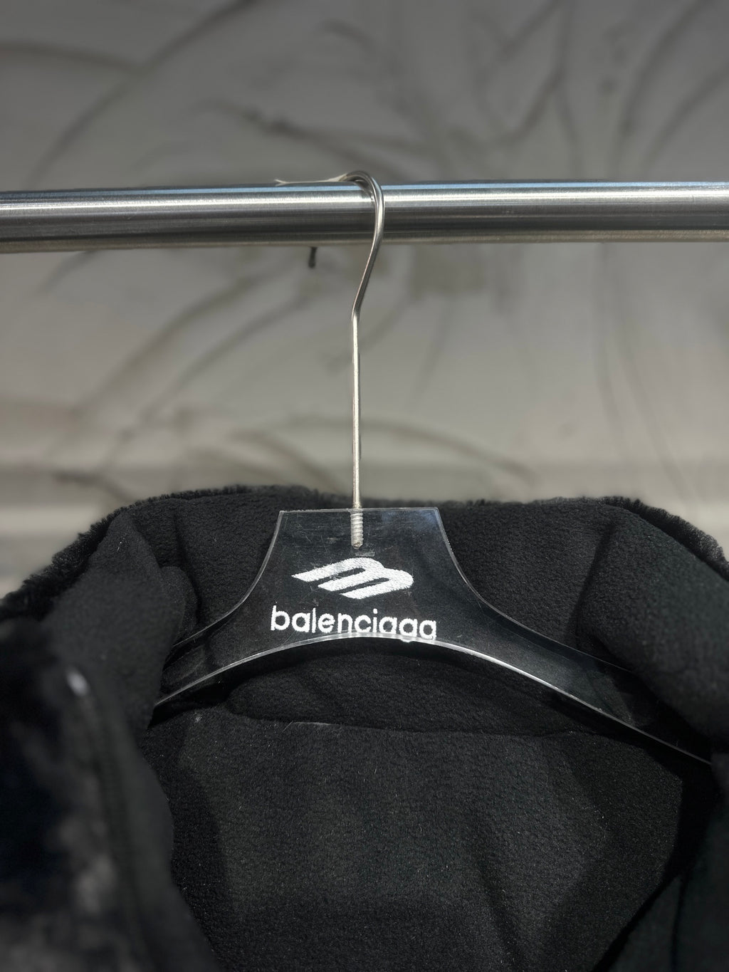 Black puffer vest interior view with Balenciaga logo on hanger label.