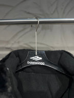 Black puffer vest interior view with Balenciaga logo on hanger label.