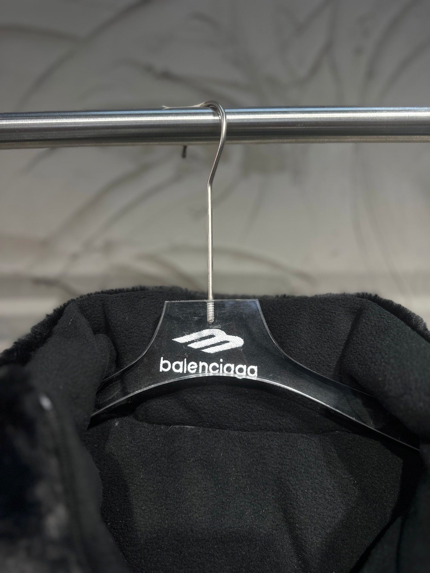 Black puffer vest interior view with Balenciaga logo on hanger label.