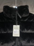 Black faux-fur puffer vest with front zipper and hanging label.