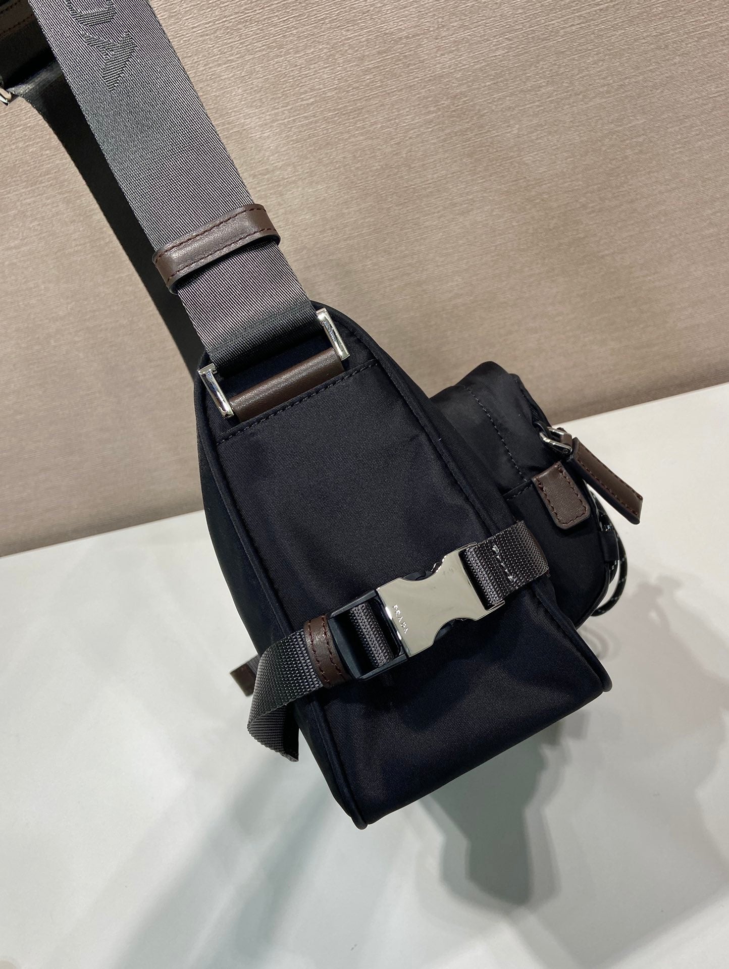 Prada nylon crossbody strap with buckles and logo webbing on dark blue bag