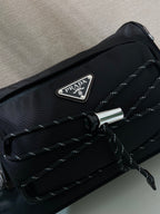 Prada nylon bag front close-up with metal PRADA logo plate and quilted trim