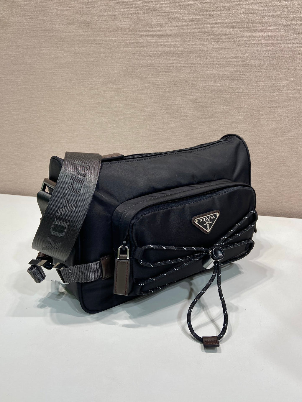 Prada nylon mini bag in dark blue with front quilted detail, logo, shoulder strap and cord