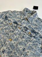 Close-up of blue denim jacket chest with pointed flap pockets and gold button details