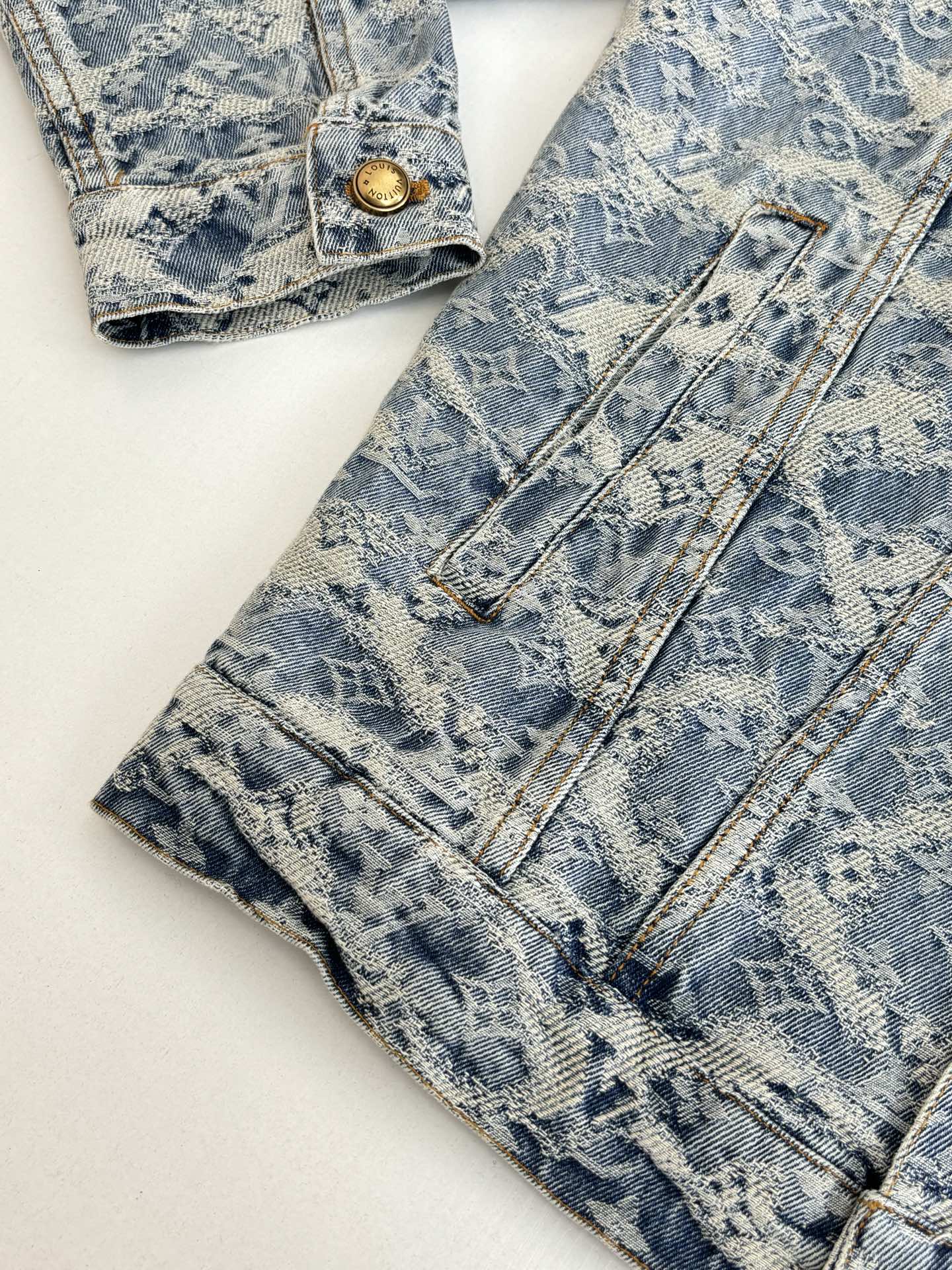 Pair of blue monogram-pattern denim pants with front button and belt loops