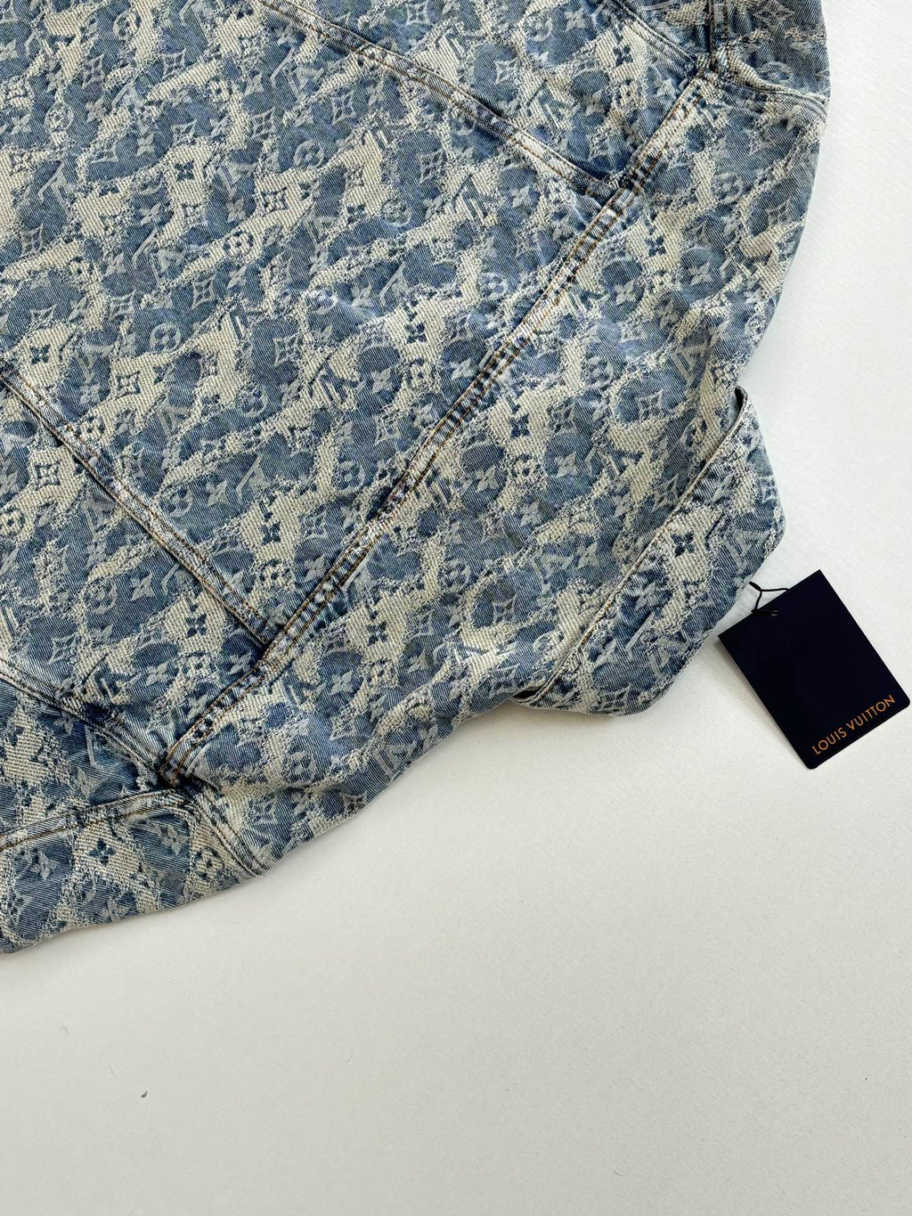 Blue monogram denim garment with diagonal seam stitching and Louis Vuitton tag