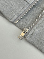 Grey zip jacket close-up with metal zipper pull and Gucci label