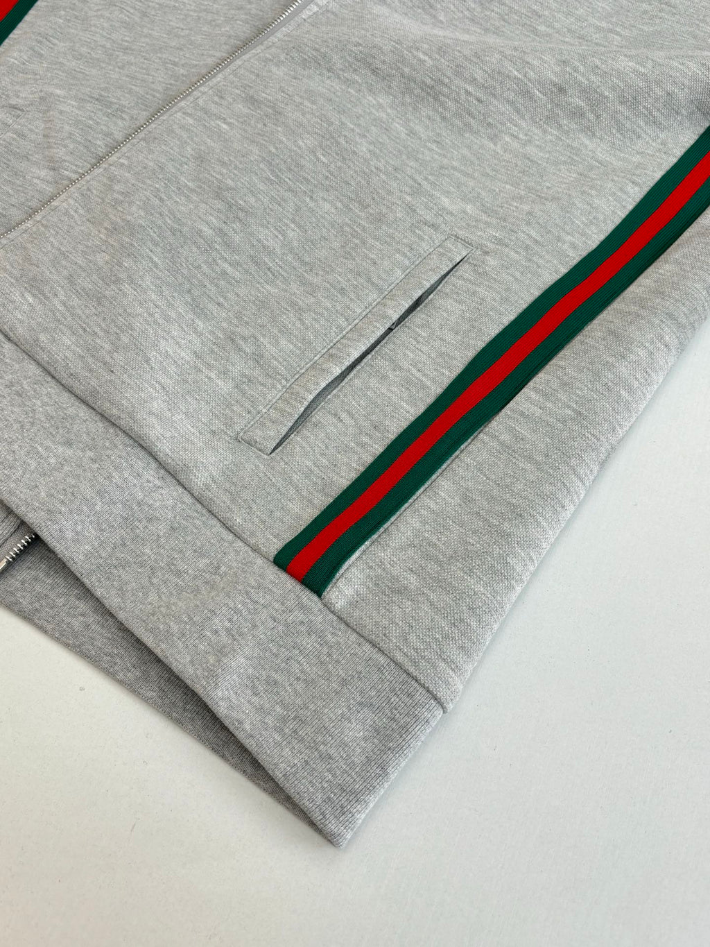 Grey pants front with green-red stripe side and small button placket