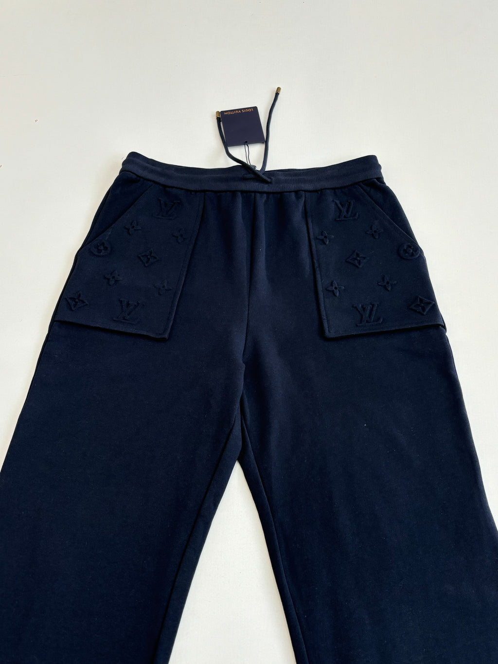 Dark navy drawstring pants with two patch pockets and monogram texture