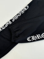 Black sweatpants with white side graphic lettering near the cuff and gathered hem.