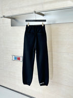 Black sweatpants with side graphic print, front view, elastic waistband and cuffs.