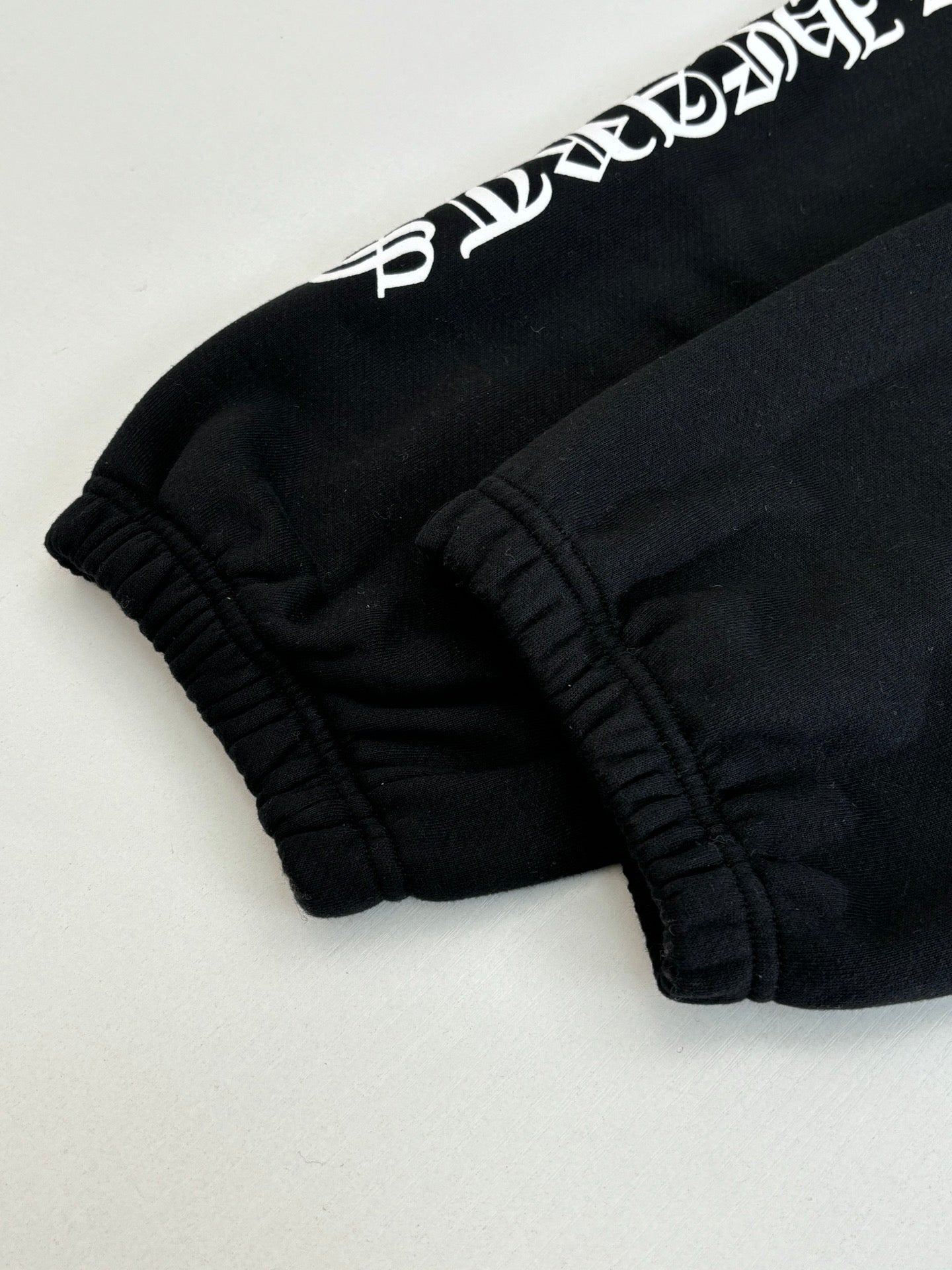 Black jogger pants with ribbed elastic cuffs, close-up of waistband area