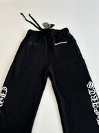 Black jogger pants, close view of drawstring waistband and graphic side print