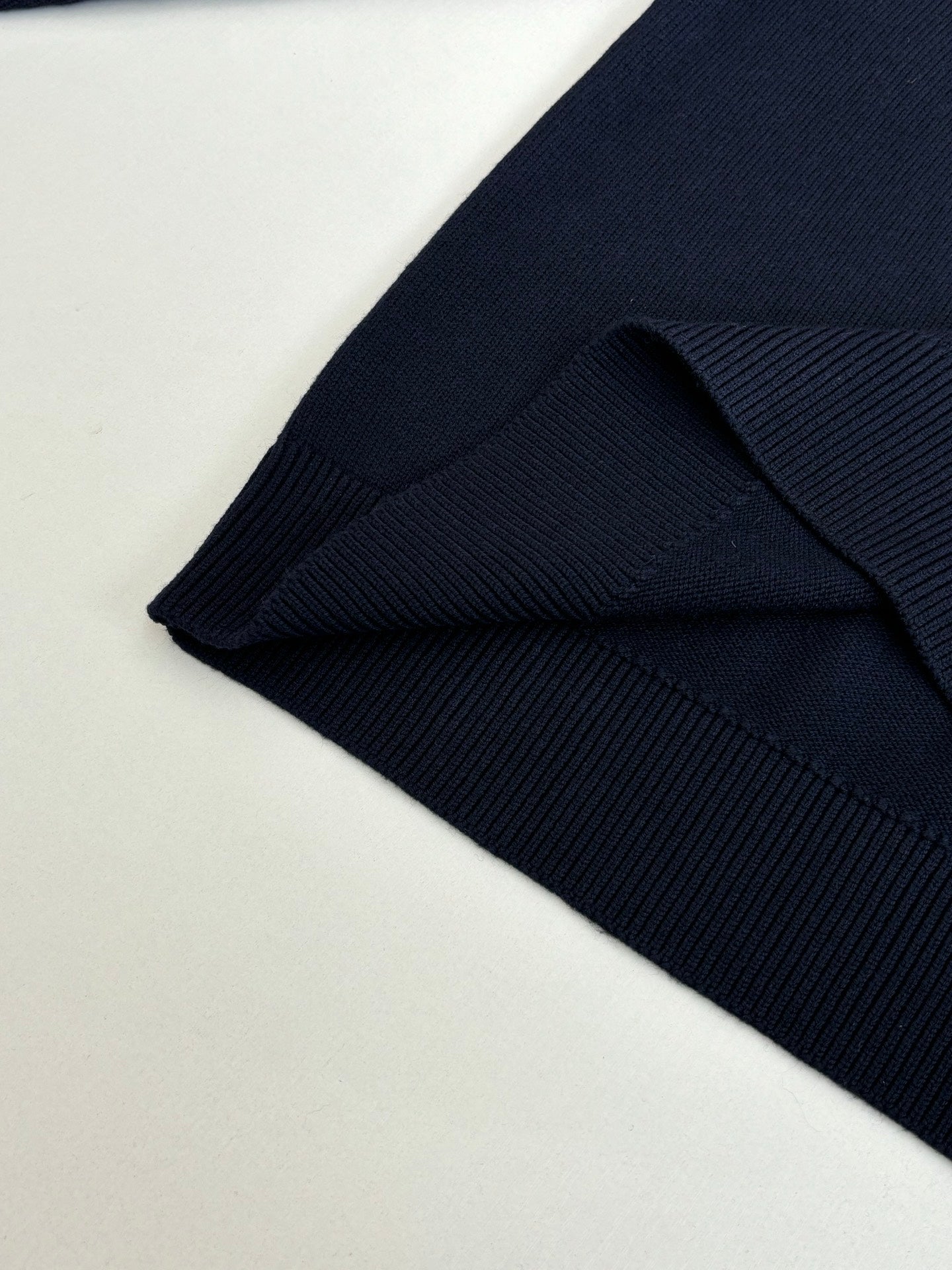 Navy sweater hem and ribbed cuff detail on long sleeves