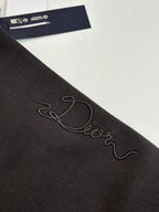 Dark sweatshirt sleeve close-up with embroidered cursive logo