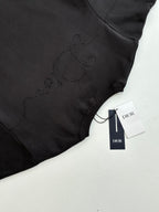 Dark sweatshirt hem close-up with embroidered logo and tag
