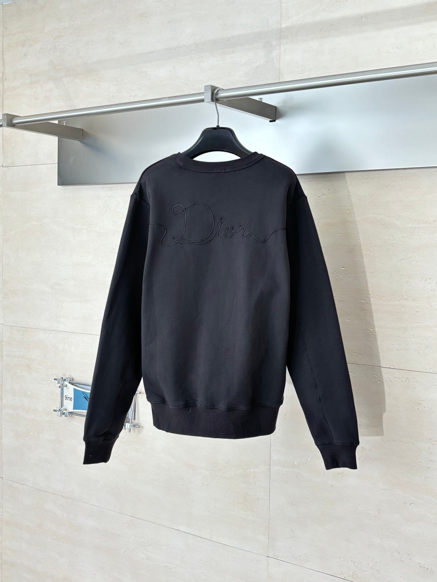 Dark long-sleeve sweatshirt, back view with subtle logo embroidery