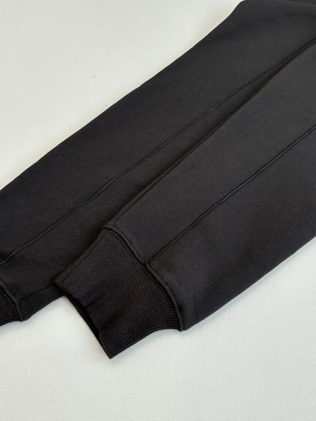 Dark sweatshirt sleeve cuff close-up with seam detail