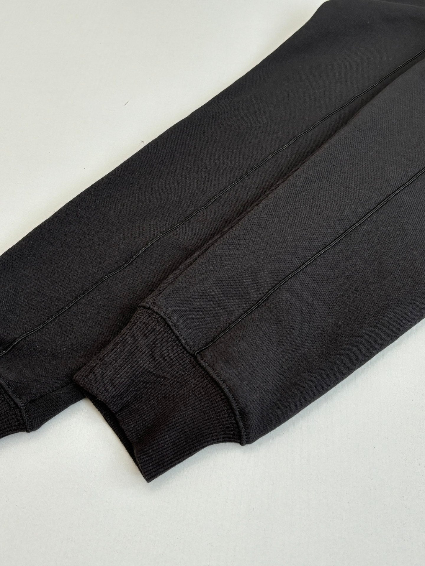 Dark sweatshirt sleeve cuff close-up with seam detail