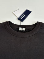 Dark crewneck sweatshirt close-up with ribbed neckline and tag