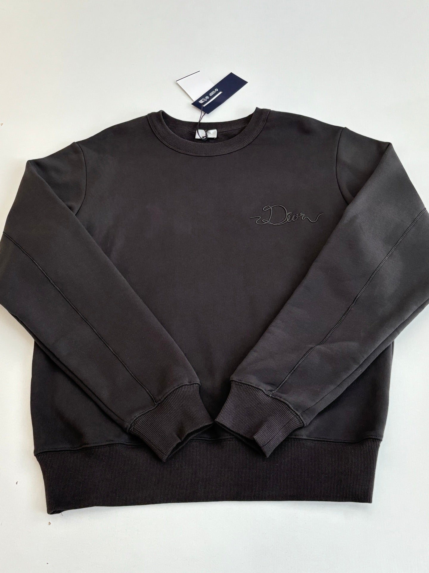 Dark long-sleeve sweatshirt with ribbed crew neck and embossed logo