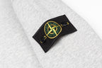 Heather gray hoodie sleeve patch with yellow-green emblem on black rectangular tab