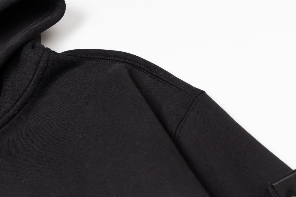 Black zip-up hoodie fabric close-up showing inner seam near zipper area