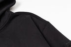Black zip-up hoodie fabric close-up showing inner seam near zipper area