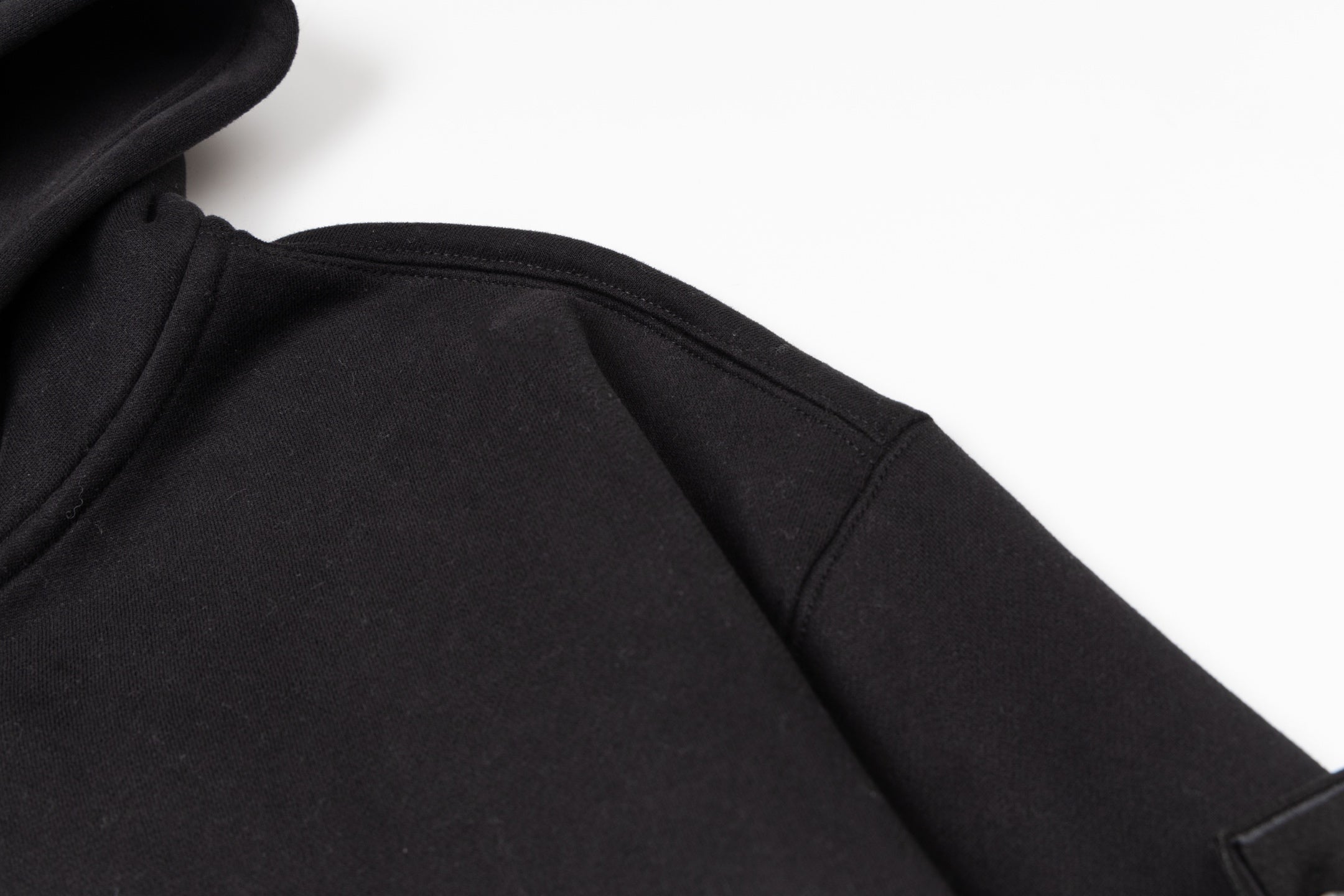 Black zip-up hoodie fabric close-up showing inner seam near zipper area