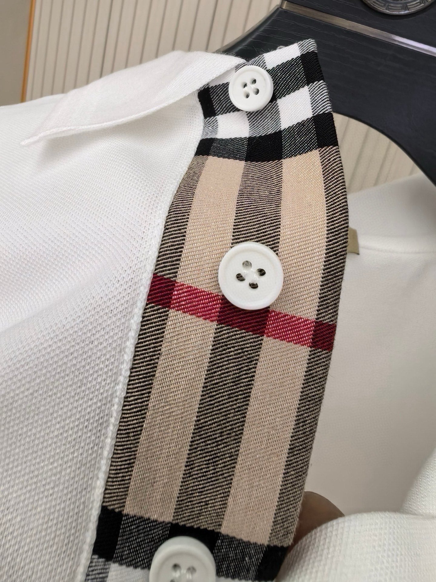White polo shirt placket with Burberry tartan trim and white buttons