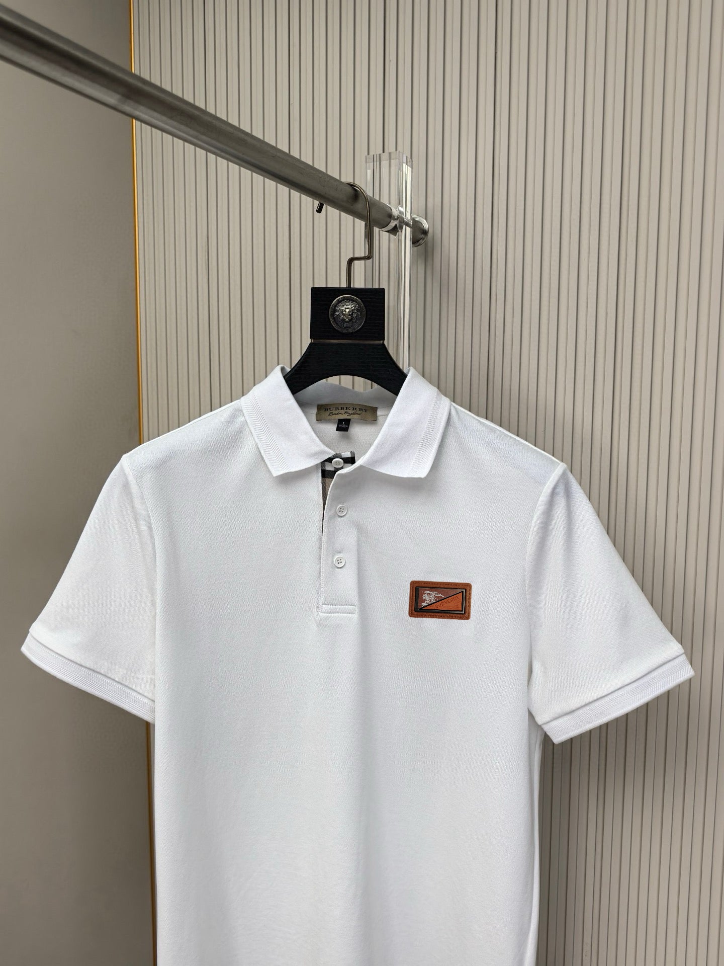 White polo shirt front with collar buttons and Burberry logo patch