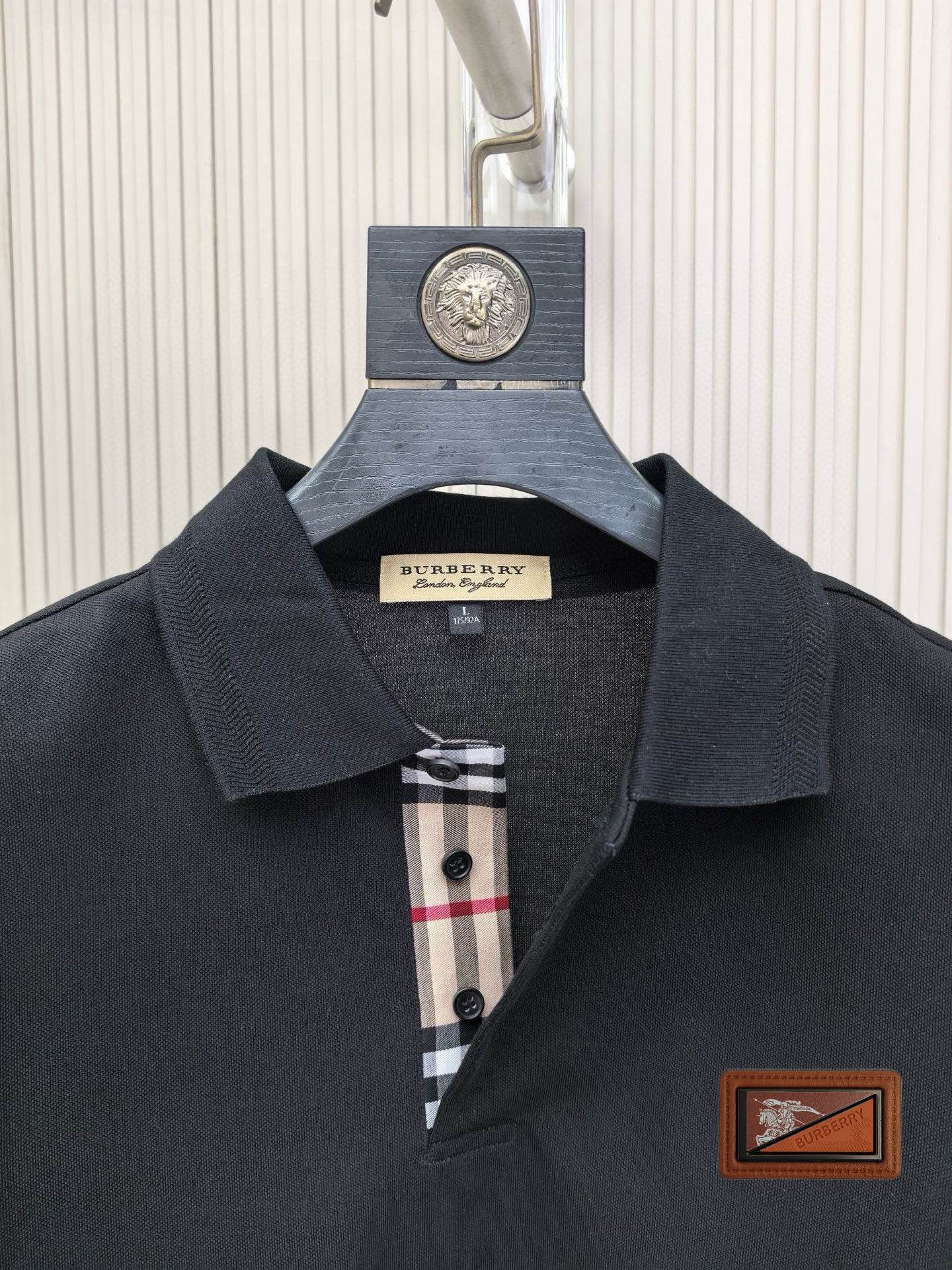 Burberry polo shirt collar close-up, dark navy with check inner placket and buttons