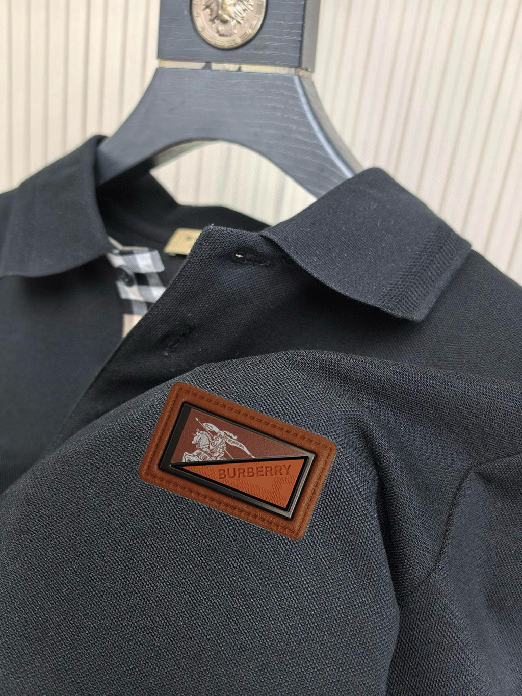 Burberry polo shirt logo patch close-up, dark navy with brown Burberry label