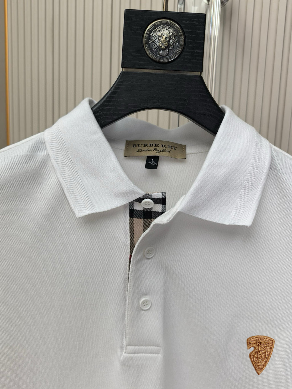 White polo shirt collar and placket with buttons, small chest emblem visible