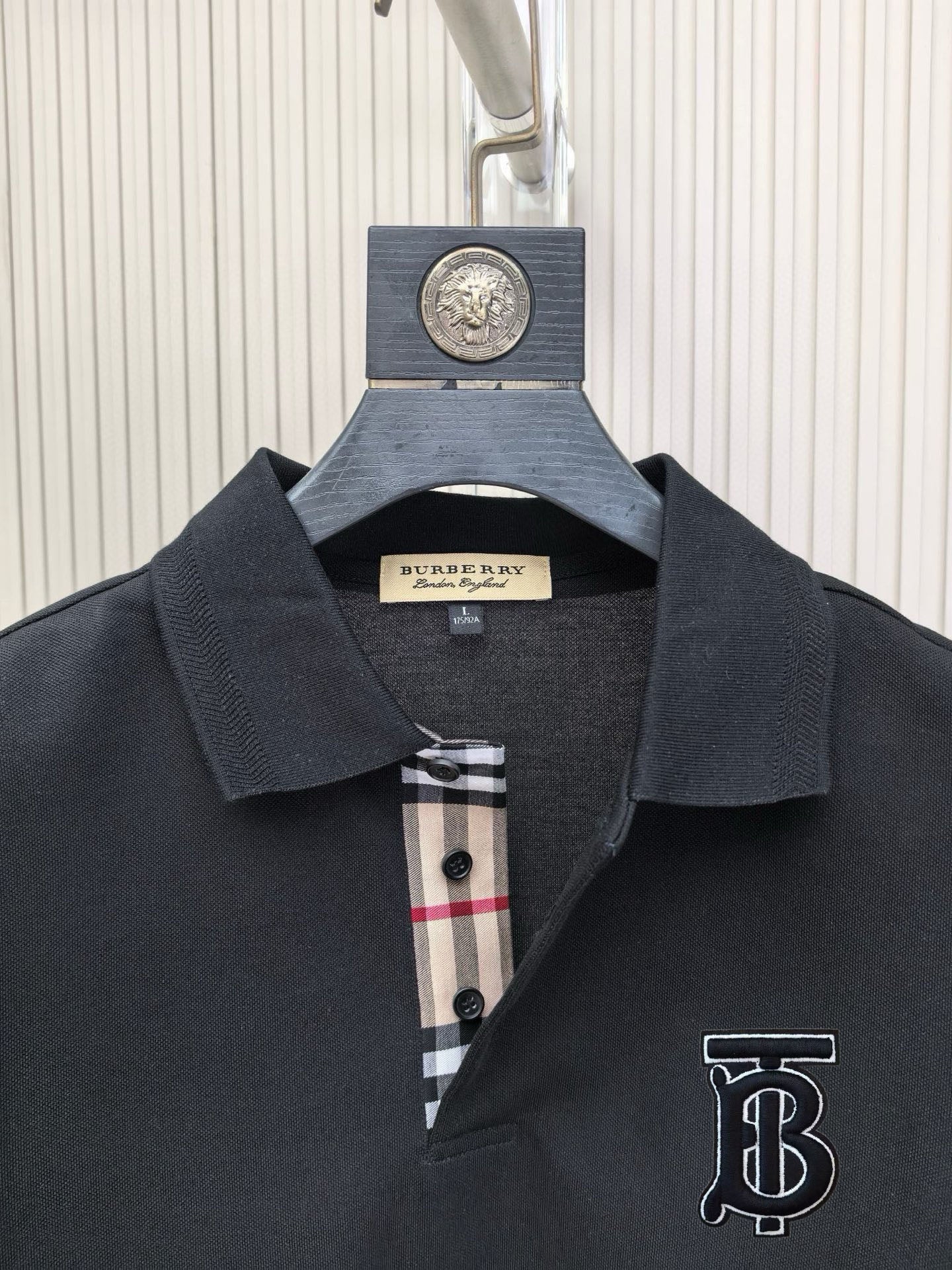 Burberry polo shirt collar and chest logo; plaid inner placket with check fabric and buttons.