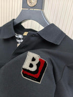 Burberry polo shirt chest patch with B emblem in black, red, and white on dark fabric