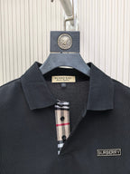 Dark navy polo shirt with pointed collar, button placket, and Burberry chest logo