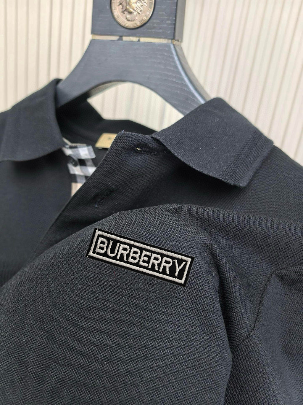 Dark navy polo shirt with Burberry logo patch on the chest